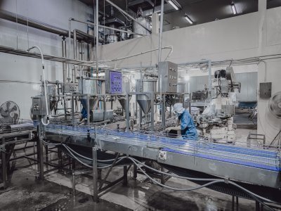 Industrial food manufacturing facility with stainless steel equipment and production line under safety inspection.