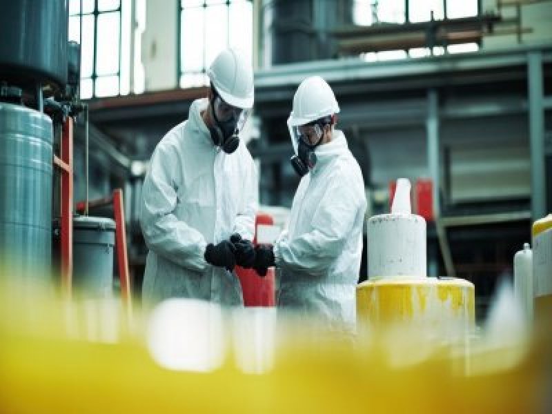 Two workers undergoing quantitative respirator fit testing in a manufacturing facility