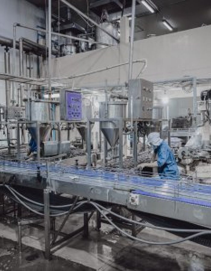 Industrial food manufacturing facility with stainless steel equipment and production line under safety inspection.